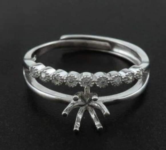 This simple elegant ring has a 6mm round prong center stone setting that can be customized with various inclusions and colors. Metal is solid 925 sterling silver and accent stones are cubic zirconia.