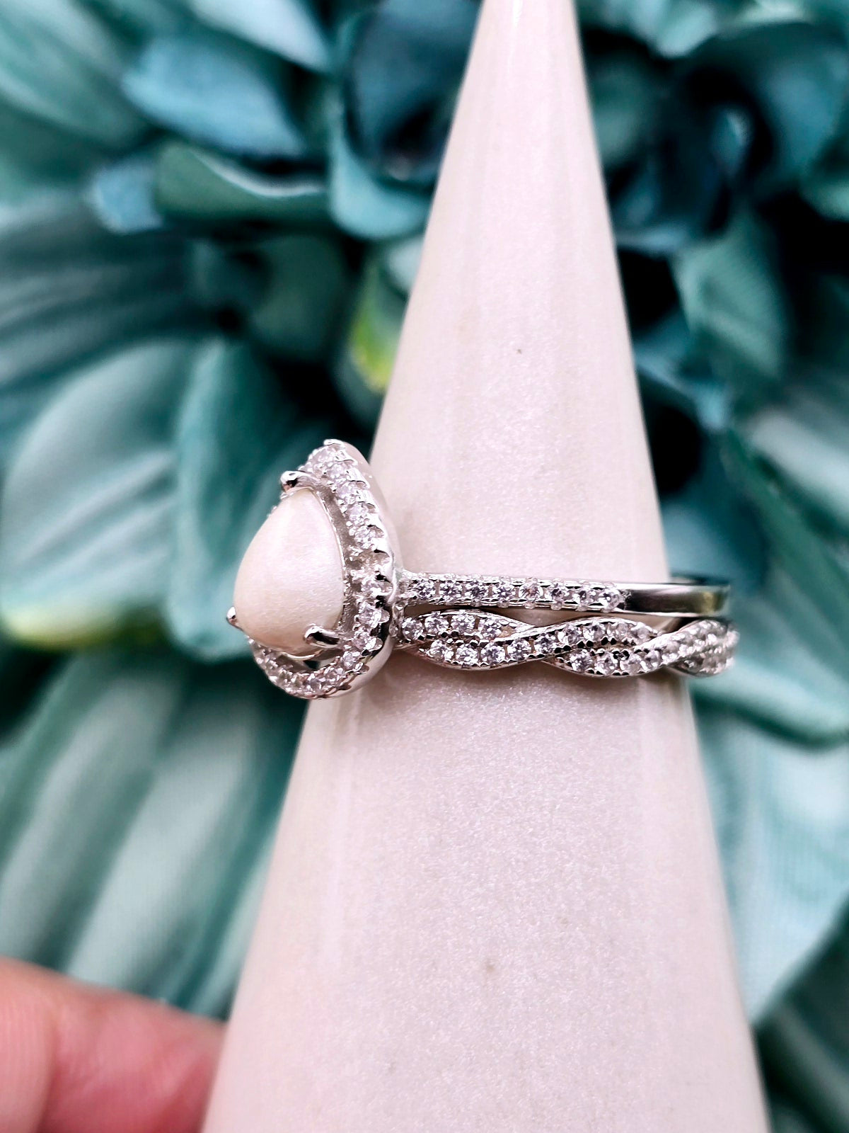 This simple, elegant pear shaped breastmilk infinity ring stacker can be customized with various inclusions and colors. Cubic Zirconia stones and sterling silver metal.