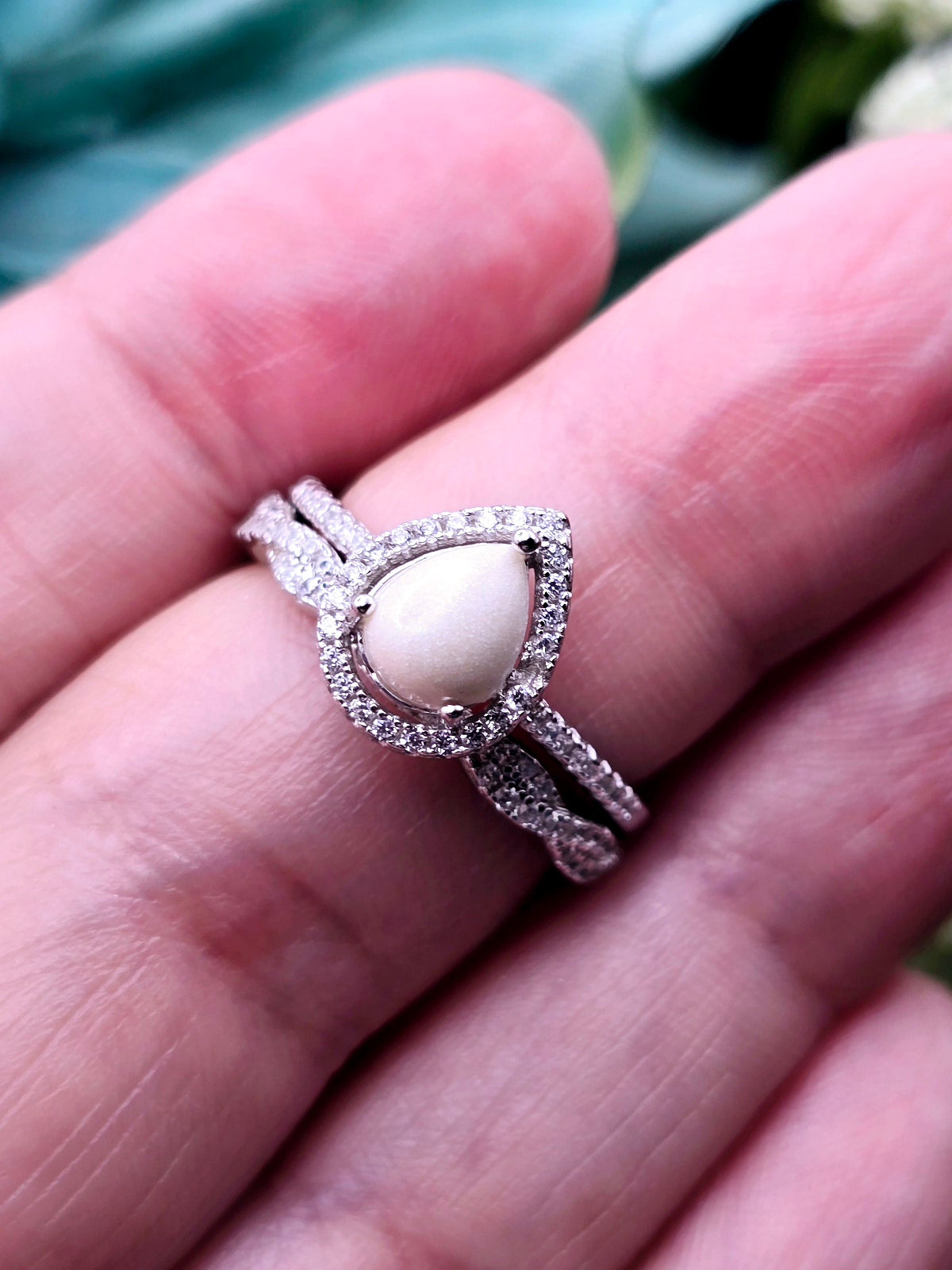 This simple, elegant pear shaped breastmilk infinity ring stacker can be customized with various inclusions and colors. Cubic Zirconia stones and sterling silver metal.