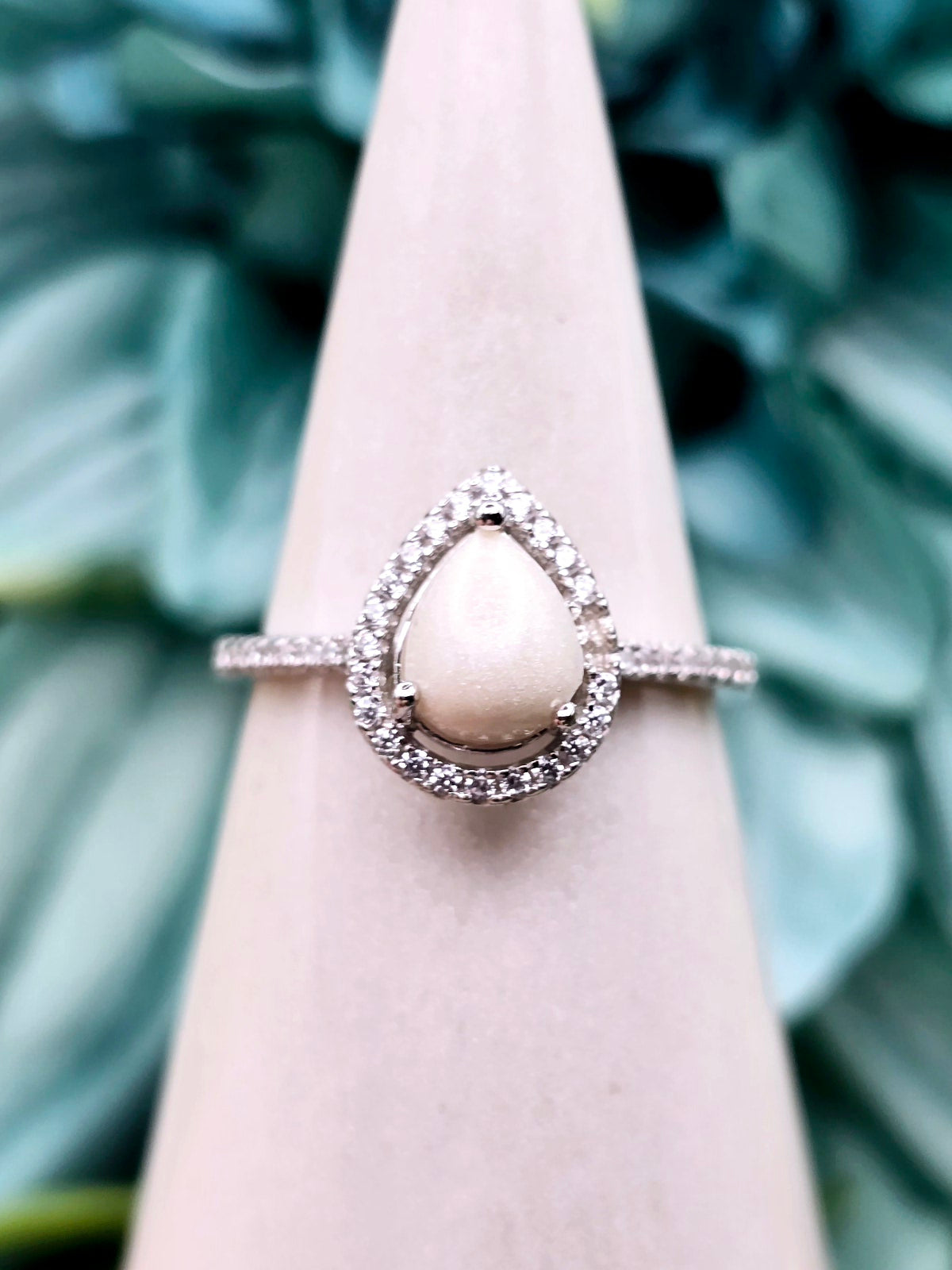 Elegant and simple, this pear shaped teardrop breastmilk ring is made with sterling silver and cubic zirconia stones. Customize with various inclusions and colors.