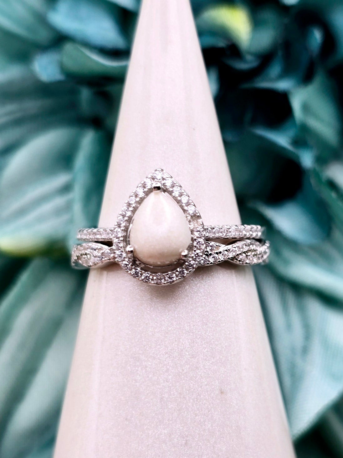 This simple, elegant pear shaped breastmilk infinity ring stacker can be customized with various inclusions and colors. Cubic Zirconia stones and sterling silver metal.